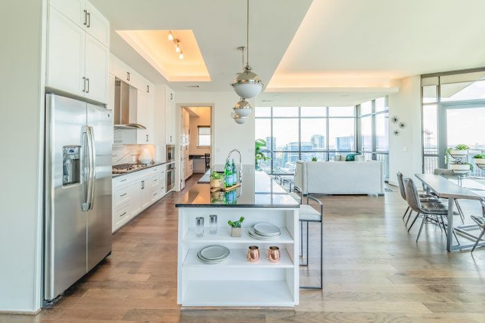 A large white kitchen with wood flooring