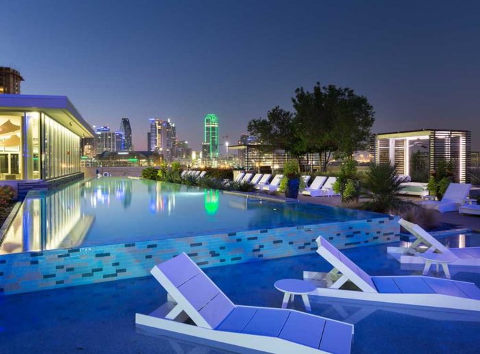 A large pool with white sun loungers