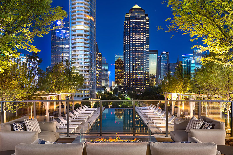 Night view of city buildings in front of a pool