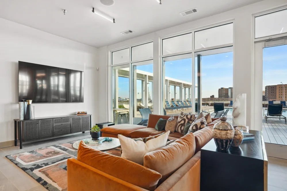 Luxury apartment living room at The Margaret at Riverfront in Dallas Texas with large windows and rooftop pool views near Uptown Dallas.